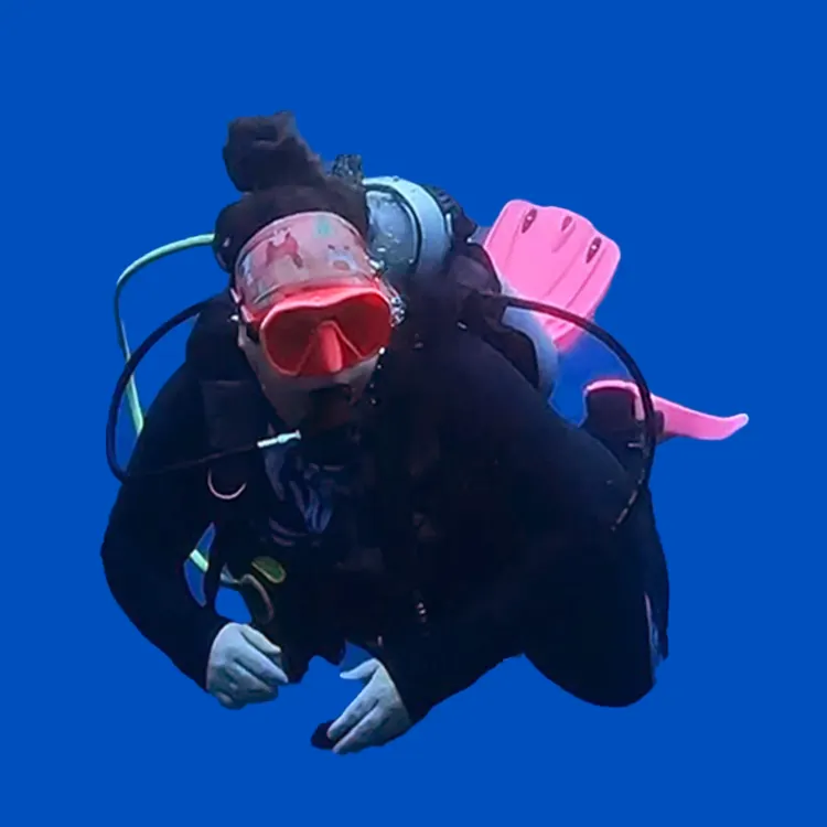 Mariya in pink fins hovering in open blue water