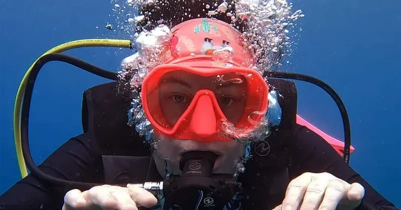 Mariya underwater in a red mask, surrounded by bubbles