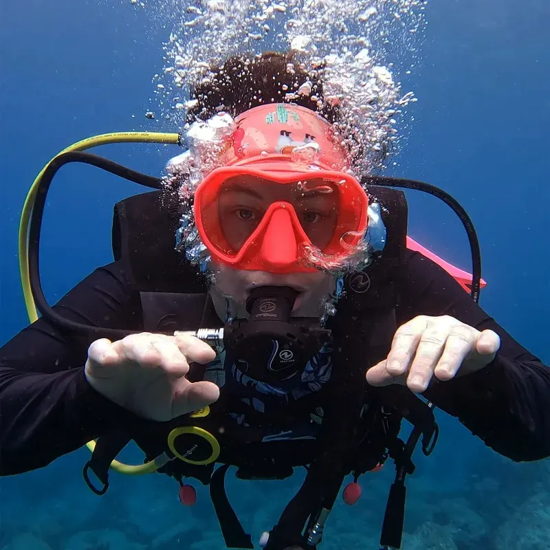 Mariya underwater in a red mask, surrounded by bubbles