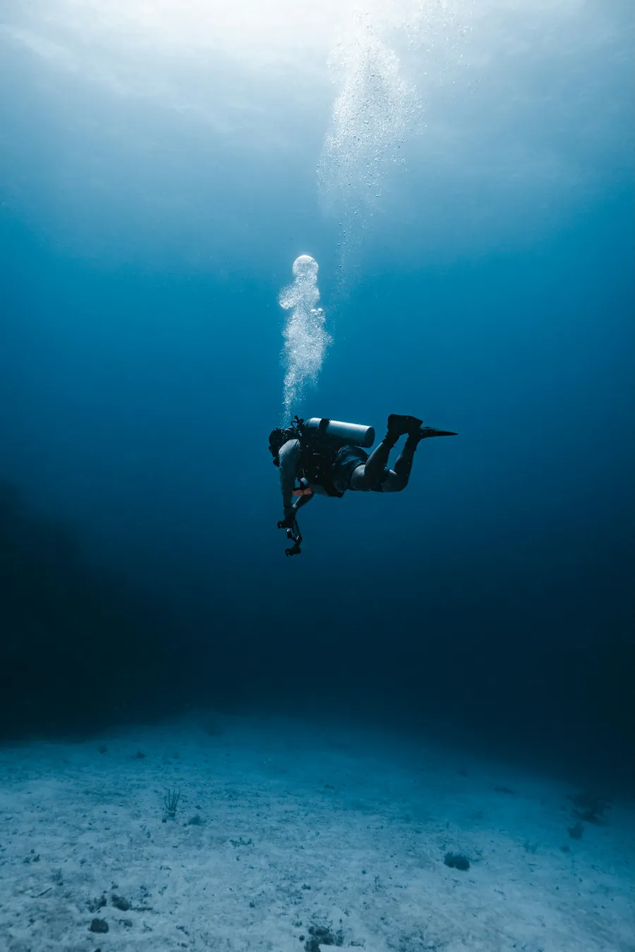 A scuba diver hovering in deep blue water