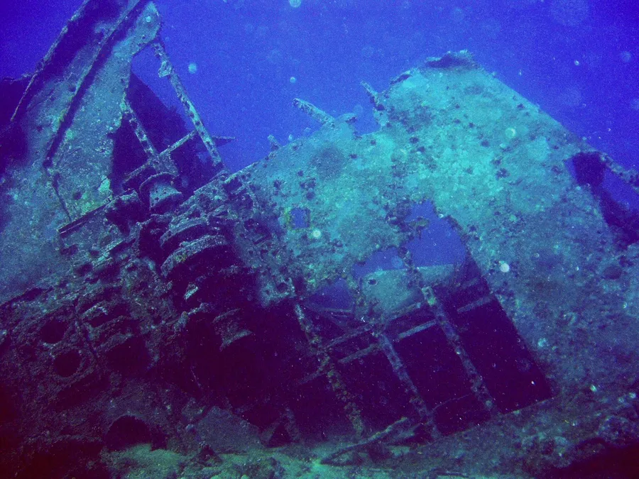 A shipwreck lit in deep blue water