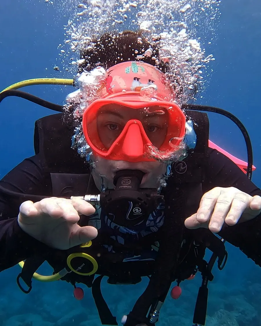 Mariya Pallais underwater, looking into the camera