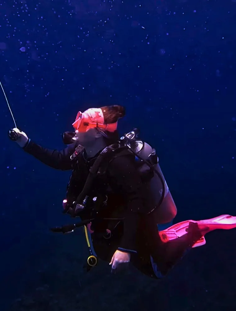 Mariya holding the descent line in dark blue water